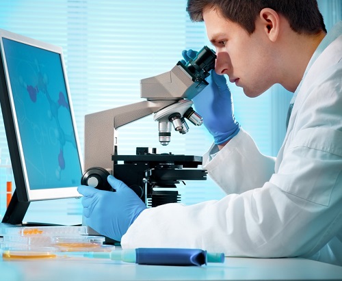 Student Looking Through Microscope On A Desk