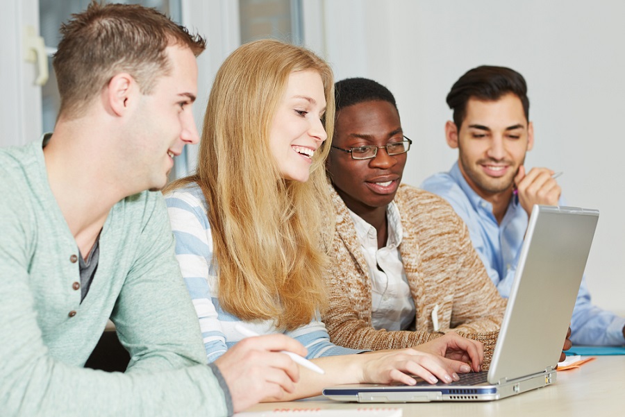 4 students looking at laptop
