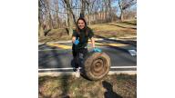 A person holding a tire.