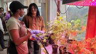 A person standing next to a person in a plant nursery