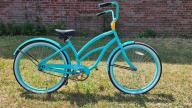 A Hyper brand turquoise green bicycle with black seat and curved handle bar with no gears