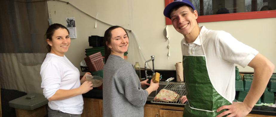 3 students cleaning up the greenhouse