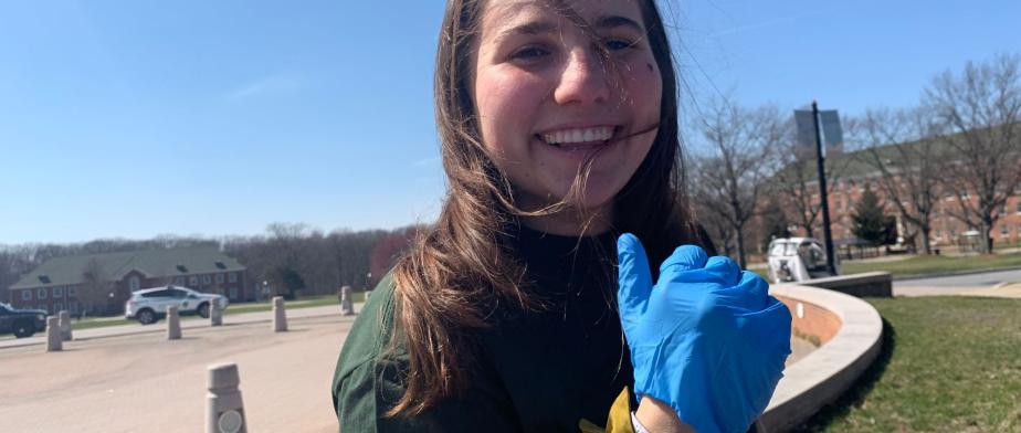 Nathalia giving thumbs up A person with long hair wearing a blue glove and smiling.