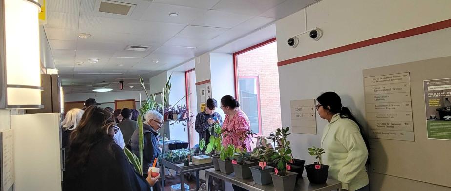 A group of people standing in a room with plants