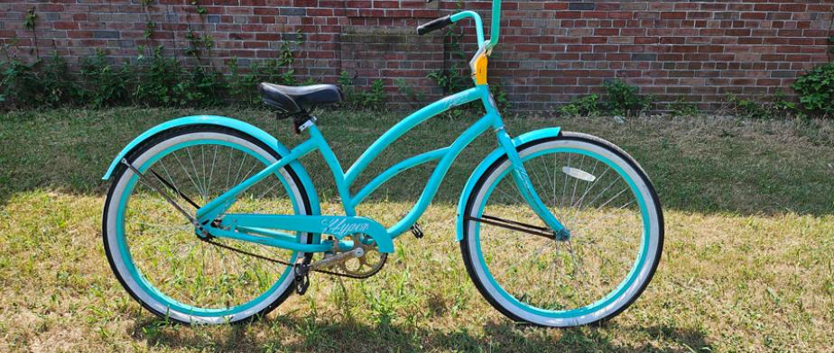 A Hyper brand turquoise green bicycle with black seat and curved handle bar with no gears