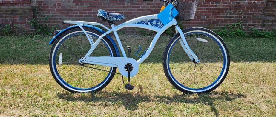 8 and 9. Cruiser A Margaritaville branded white - framed bike with black handlebars, a black basket, a cup holder, pedal breaks, and a white and navy blue palmtree - decorated seat.