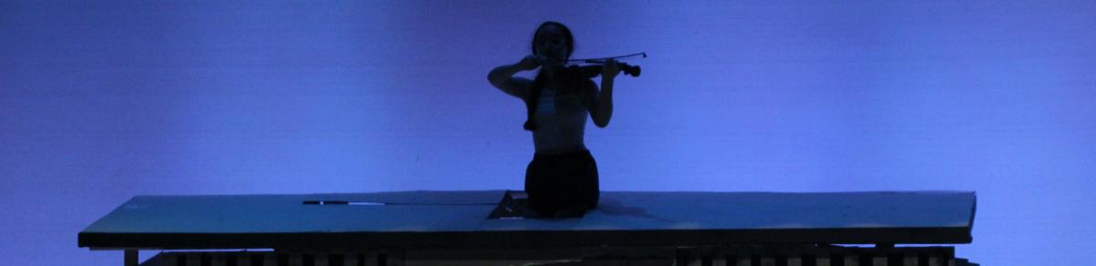 A woman playing a fiddle on stage