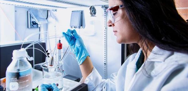 Student in Lab Coat Performing an Experiment