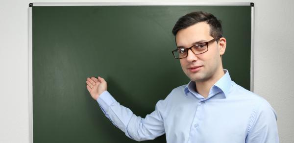 Male instructor in front of blackboard