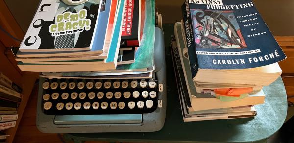 pile of books and a typewriter