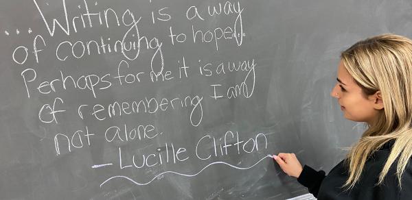 student writing on a blackboard