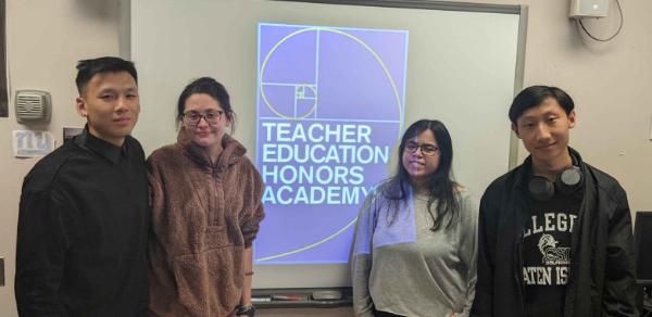 A group of Students Posing in Front of the TEHA Logo