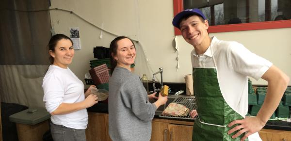 3 students cleaning up the greenhouse