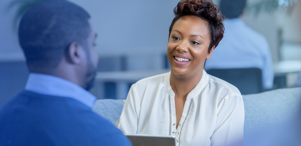 Young woman happily in conversation with male in office setting