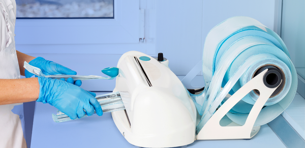 a person in blue gloves processing medical tools in sterile packaging in medical setting