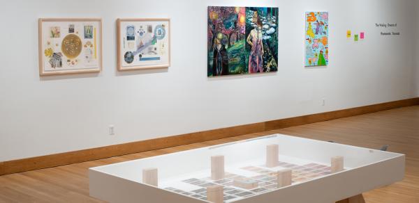 exhibit floor with pictures on the walls and a table with objects