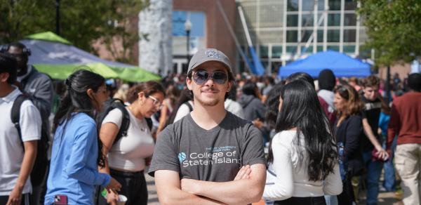 a student wearing CSI Logo t-shirt and a cap