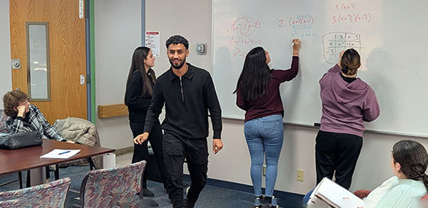 Students Standing And Writing on a Whiteboard