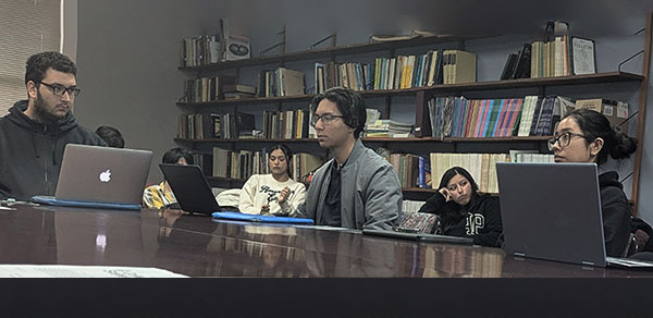 Students at a Table Working on Laptops