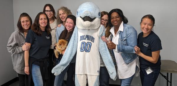 a group of people with a dolphin mascot 