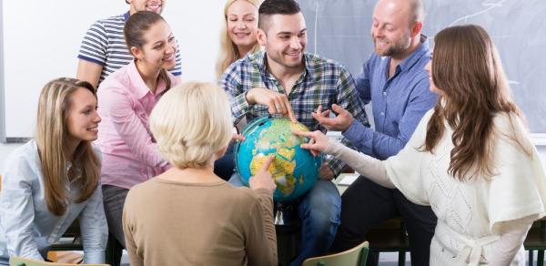 Group of students pointing to a globe