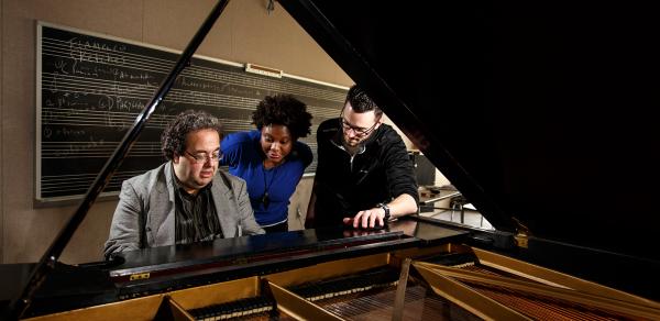 CSI Music students playing piano alongside teacher