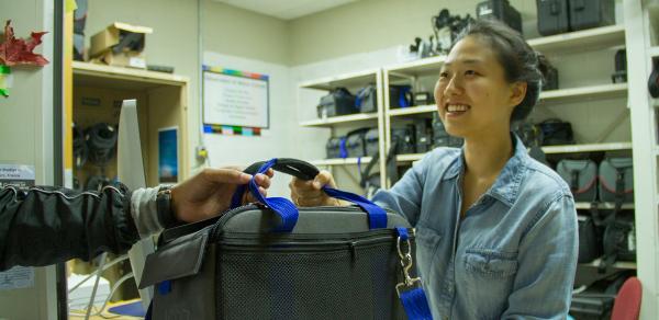 Media Culture Student picking up camera equipment