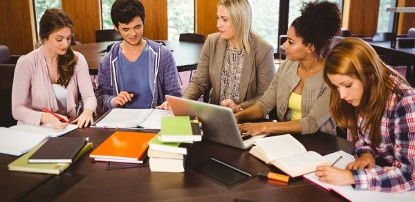 group of students sitting at table with tutor