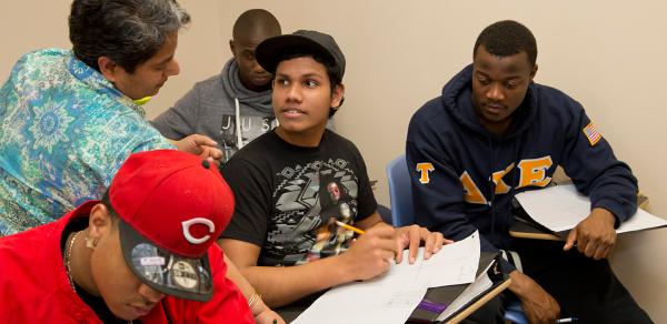 group of students sitting at table with tutor