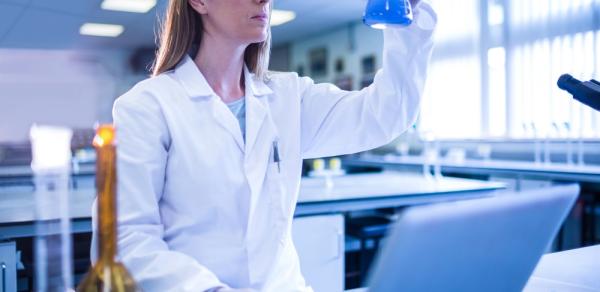 female student in lab wearing white lab coat