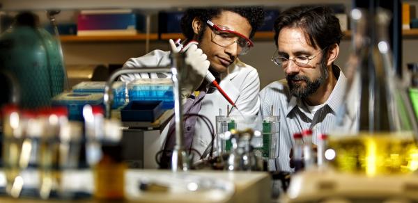 2 males with beakers in lab