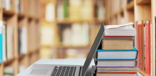 library shelves with laptop and books