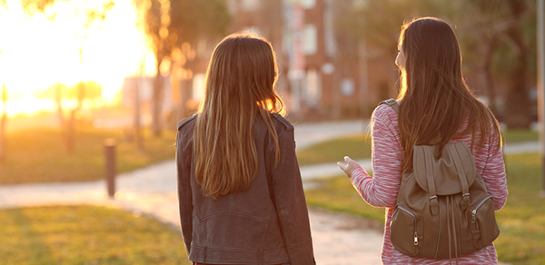 Students walking towards sunset