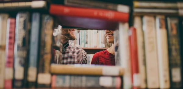 Students laughing behind books