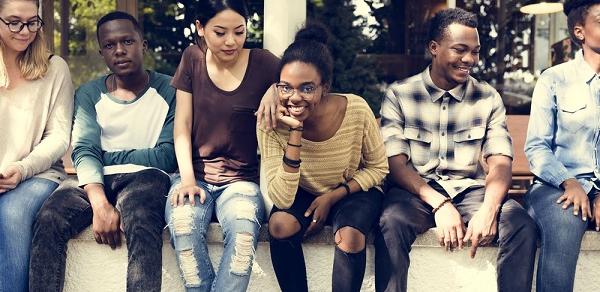 students sitting on wall with laptop