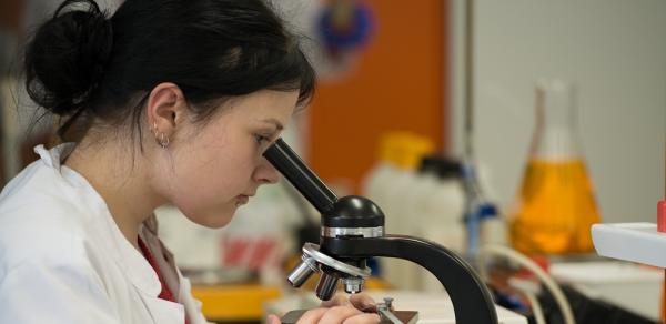 Female Student Looking In Microscope