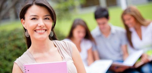 Student Holding Pink Textbook Outside