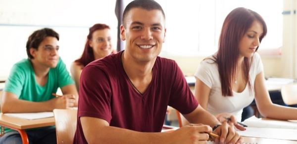 Students Writing At Desk In Class