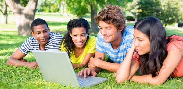 Students Looking On At Laptop Outside