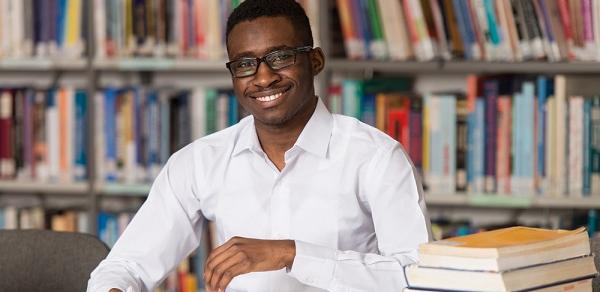 Student Sitting In Library With Books