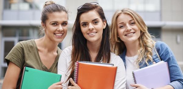 Three Students Holding Colored Notebooks