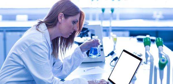 Student In Labcoat Working On Computer