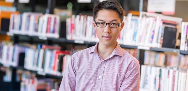 Student Standing In Front Of Bookcase