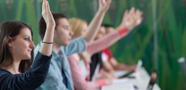 Students raising their hands in classroom