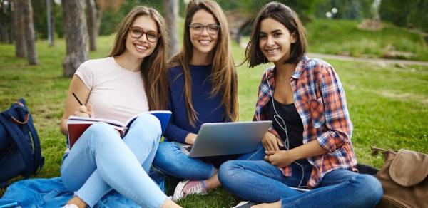 Threee Students Outside Looking At Laptop