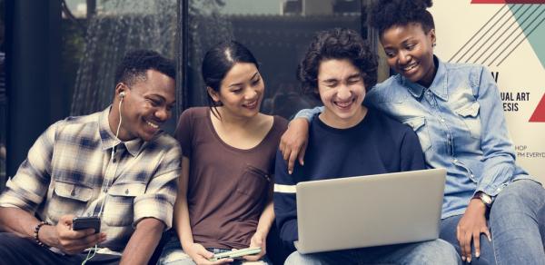 4 students on bench with laptop