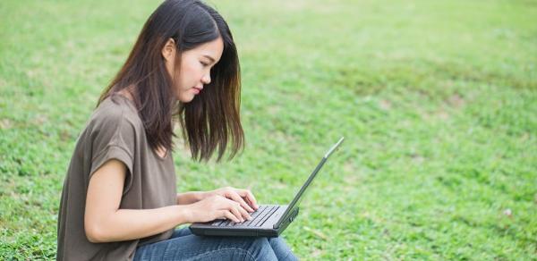 Student Alone On Grass With Laptop