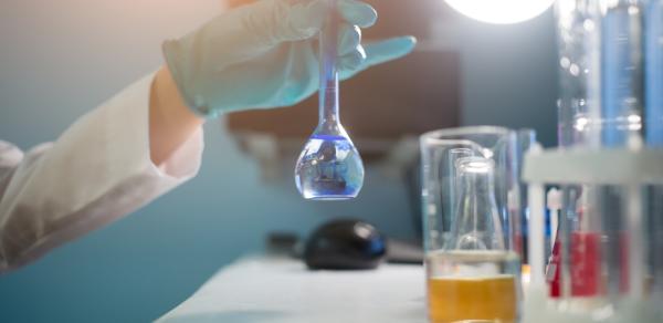 Student pouring liquids from a flask in to a beaker