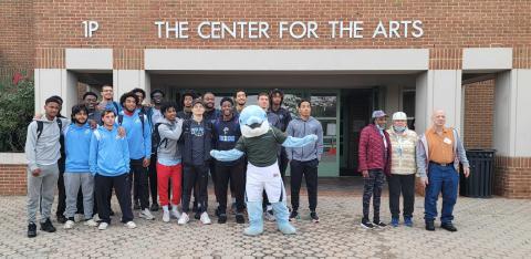 Students and staff with Danny the mascot in front of 1 P The Center of the Arts building.  ​
