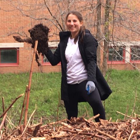 Natalia holding the root of Japanese Knotweed. An invasive species her club try to eradicate